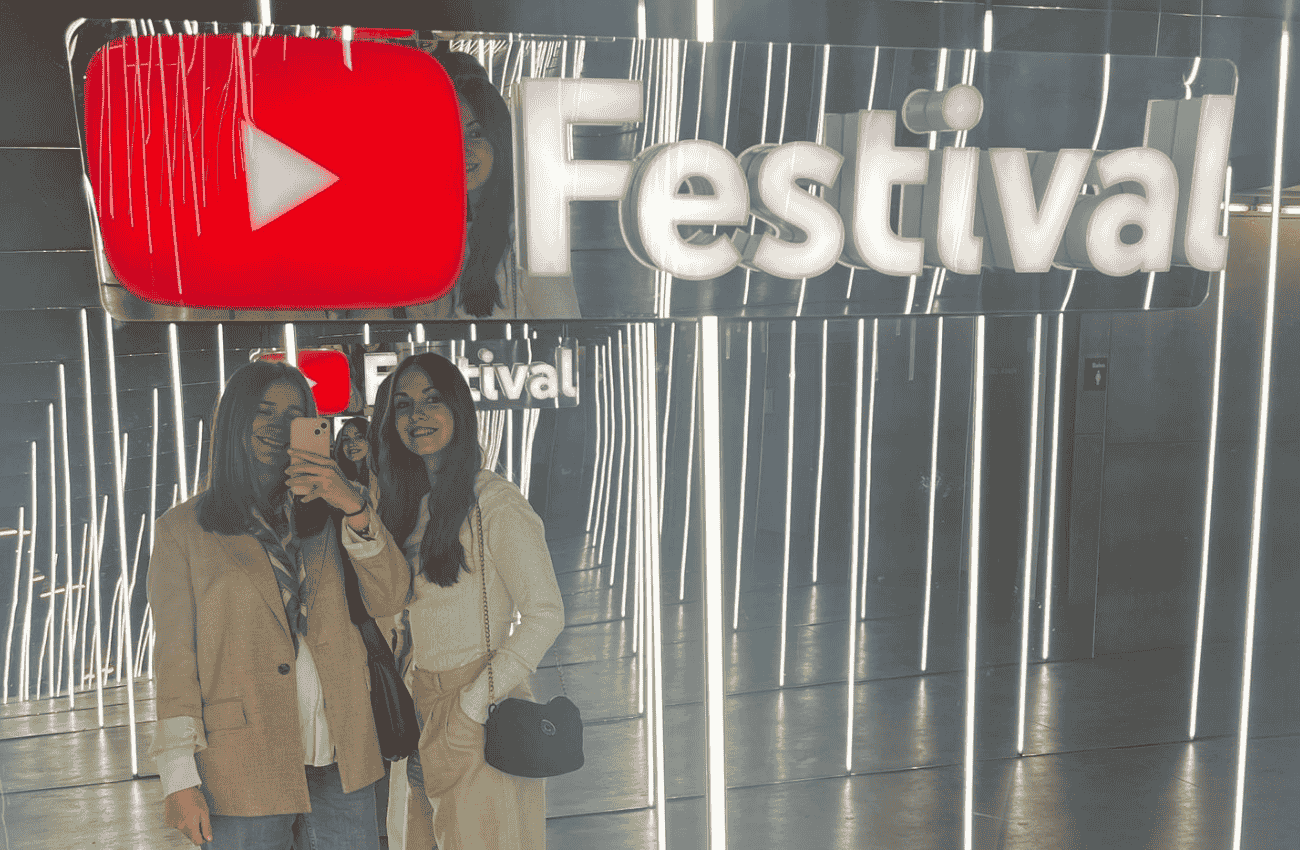 Dos chicas en el YouTube Festival de España, con el logo de YouTube Festival de fondo.
