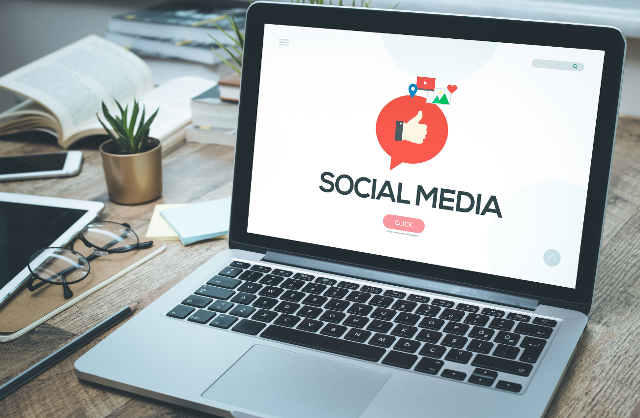 Laptop mostrando "Social Media" con ícono de pulgar arriba. Claves para mejorar tu estrategia.